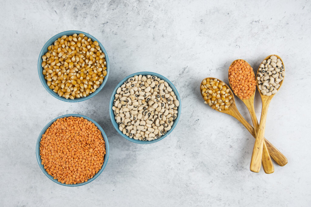 bowls full of raw beans and wooden spoons